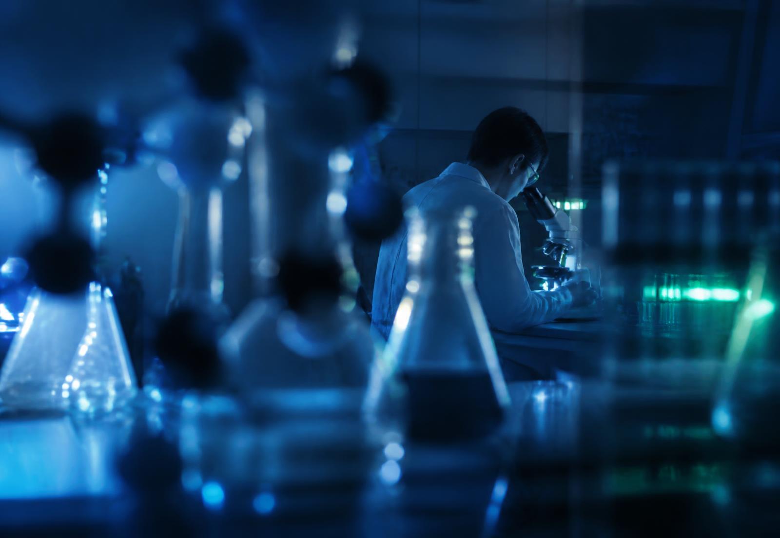 Researcher at a microscope in a life sciences laboratory